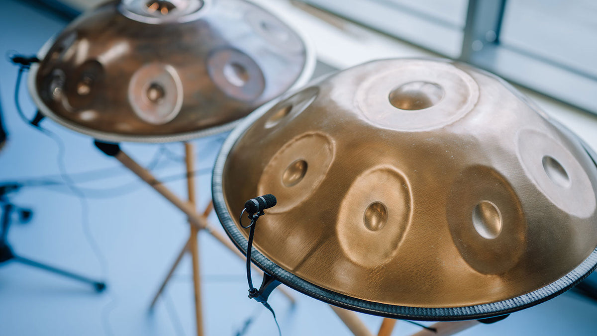 Two microphone-equipped handpans are set side by side for a concert, tuned to A=440 Hz.